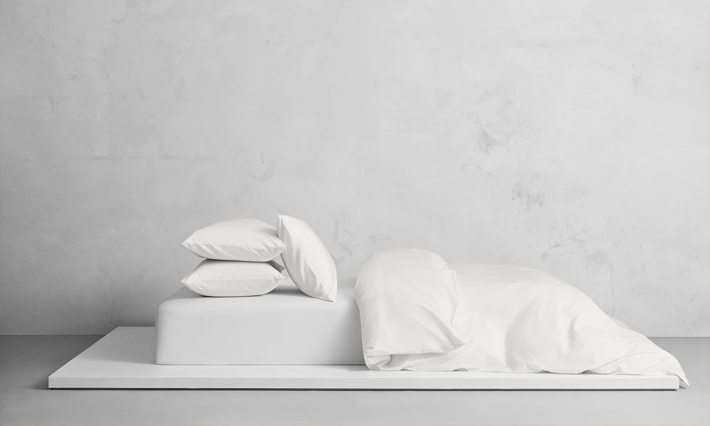 Uppbäddad säng i Naked Percale Ogland White, tillverkad i ekologisk bomull med 250 trådtäthet. Krispiga vita påslakan och örngott i percale.
