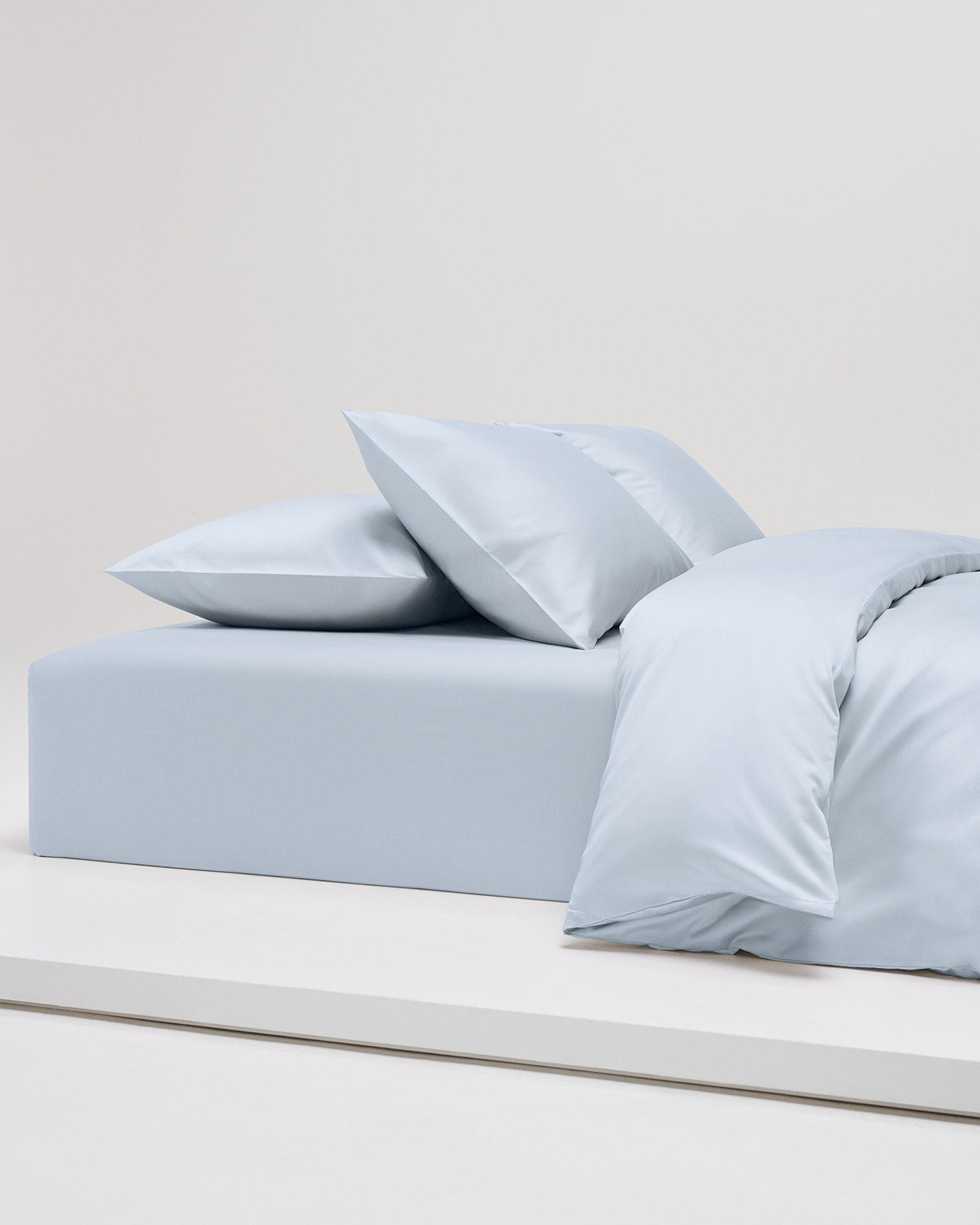 Örngott, påslakan och flat sheet i Shade Ice Blue satin. Tillverkade i 100 % ekologisk bomull med GOTS-certifiering. Exklusiva blå sängkläder i satin.
